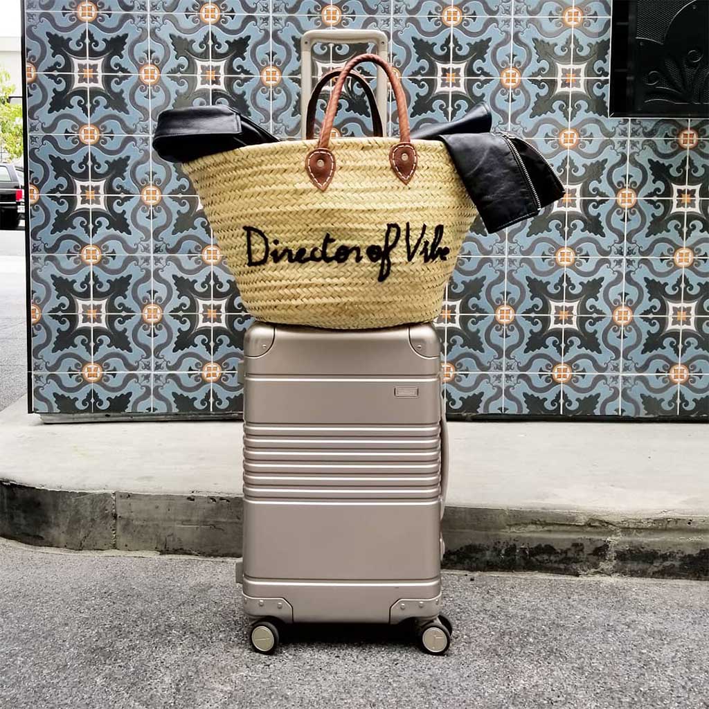 Frame carry-on in champagne aluminum edition with customer's personal purse on top.