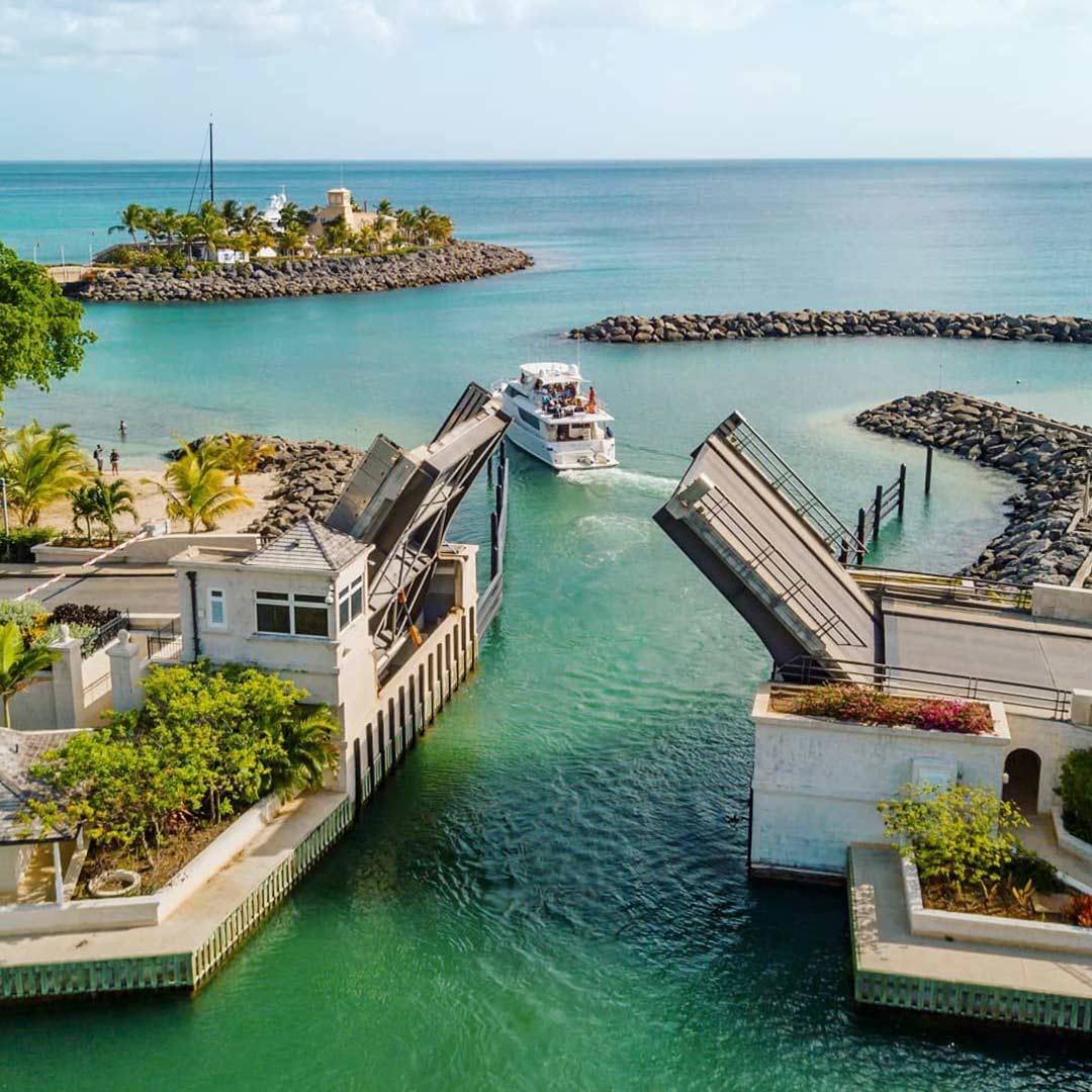 A view of a turquoise waters and drawbridge in Barbados with the lanes lifted so that a ship can pass through.