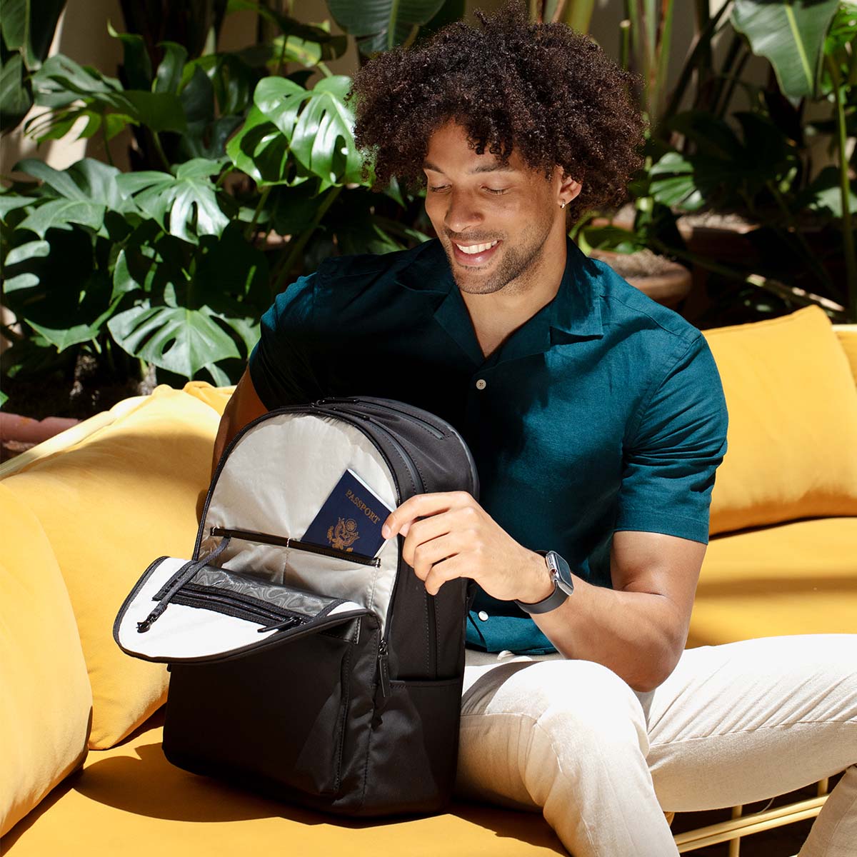 man removing passport from front pocket of backpack