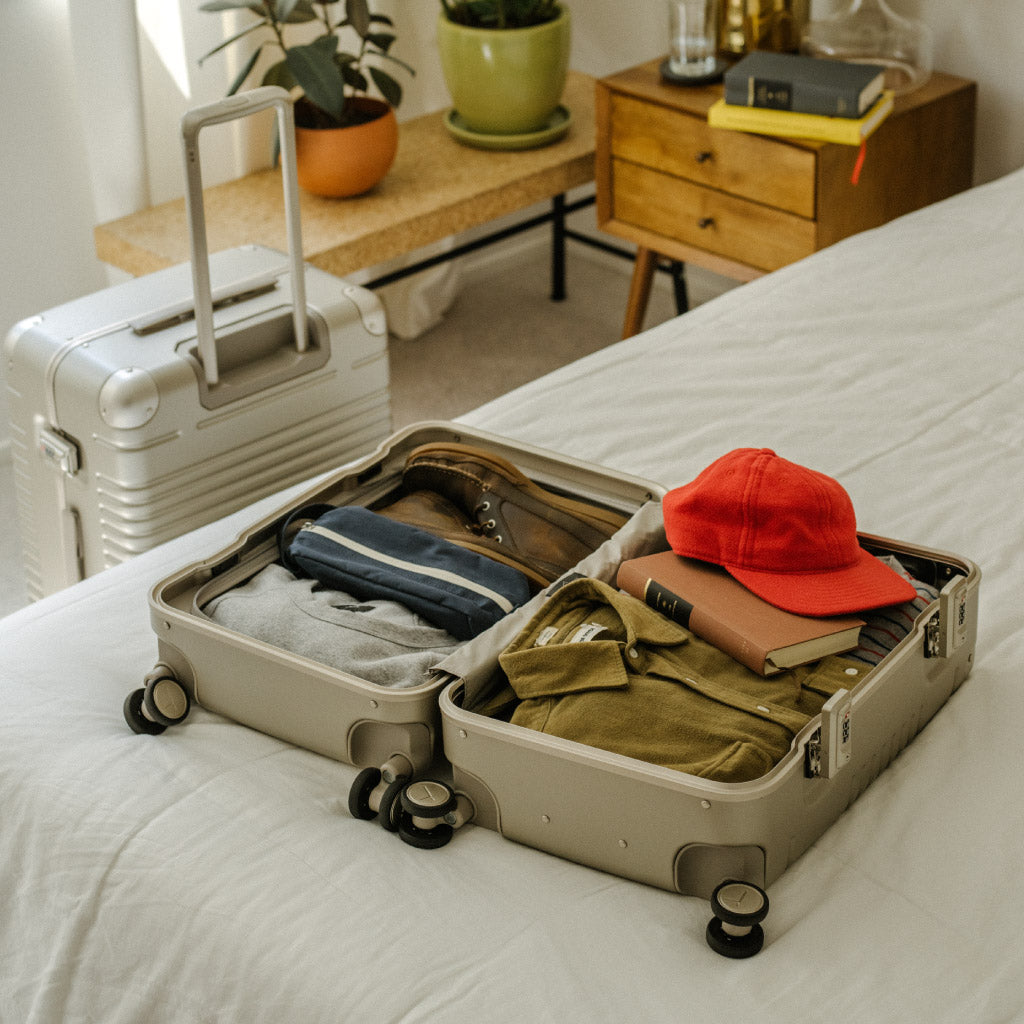 champagne frame carry-on laying flat open on the bed