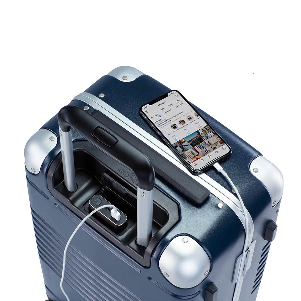 Top down view of frame carry-on max in navy blue showing the spare charger in use