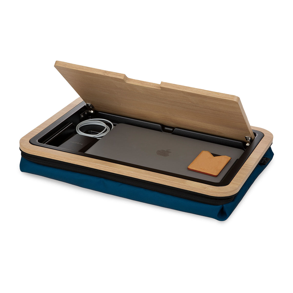 Lid of lap desk with navy cushion open at 45 degree angle with storage tray below visible.