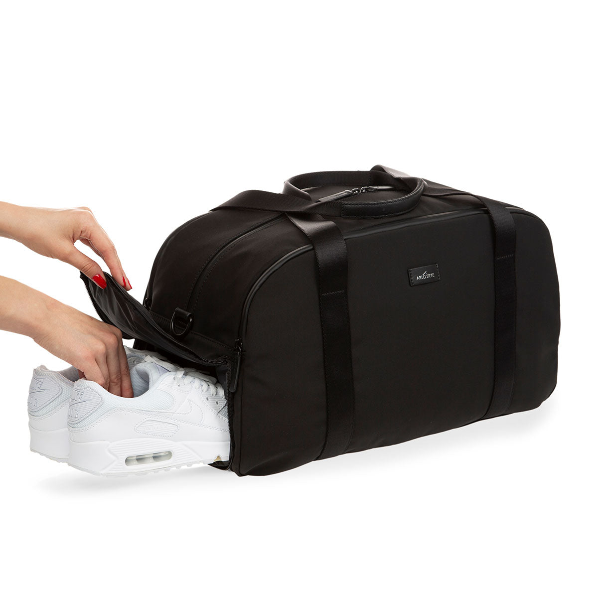 weekender in black - 3/4 angle view showing one pair of shoes being slid into the shoe compartment.