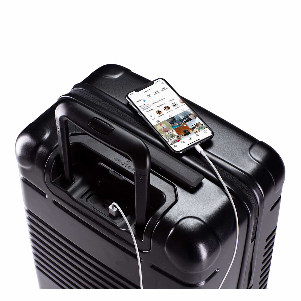 Top view of the zipper carry-on max in black with spare charger in use