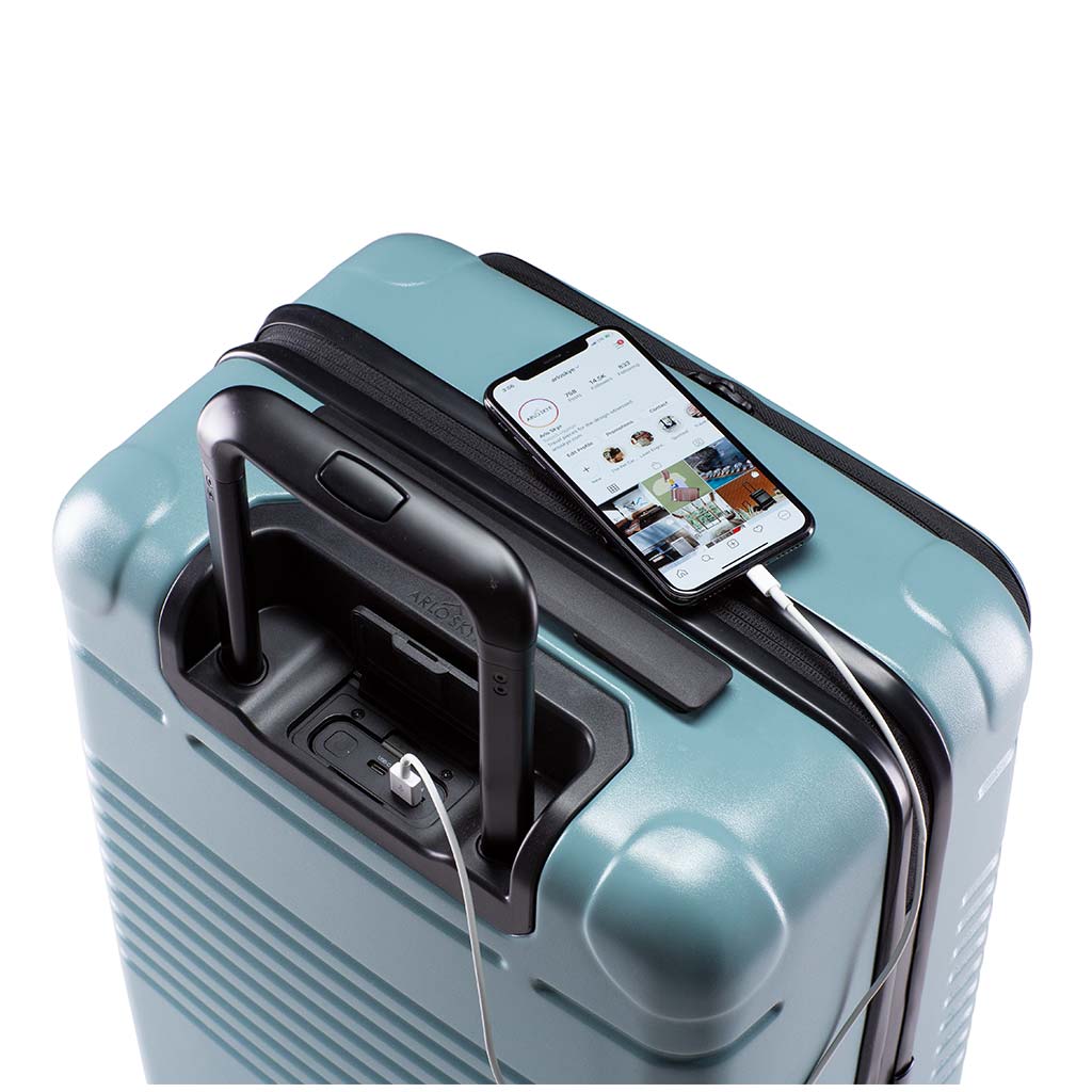 Top down view of the zipper carry-on max with front pocket in sea sage with spare charger in use