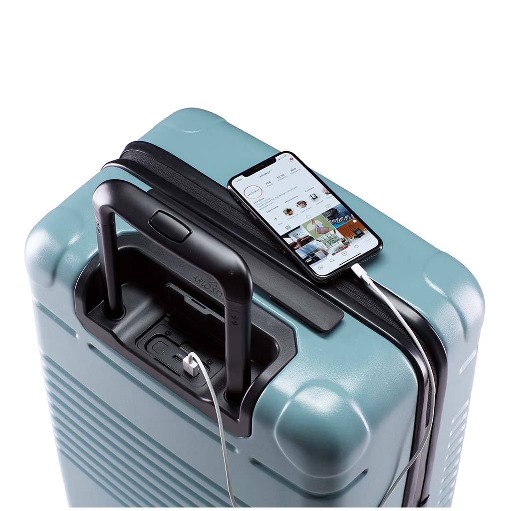Top view of the zipper carry-on max in sea sage with spare charger in use