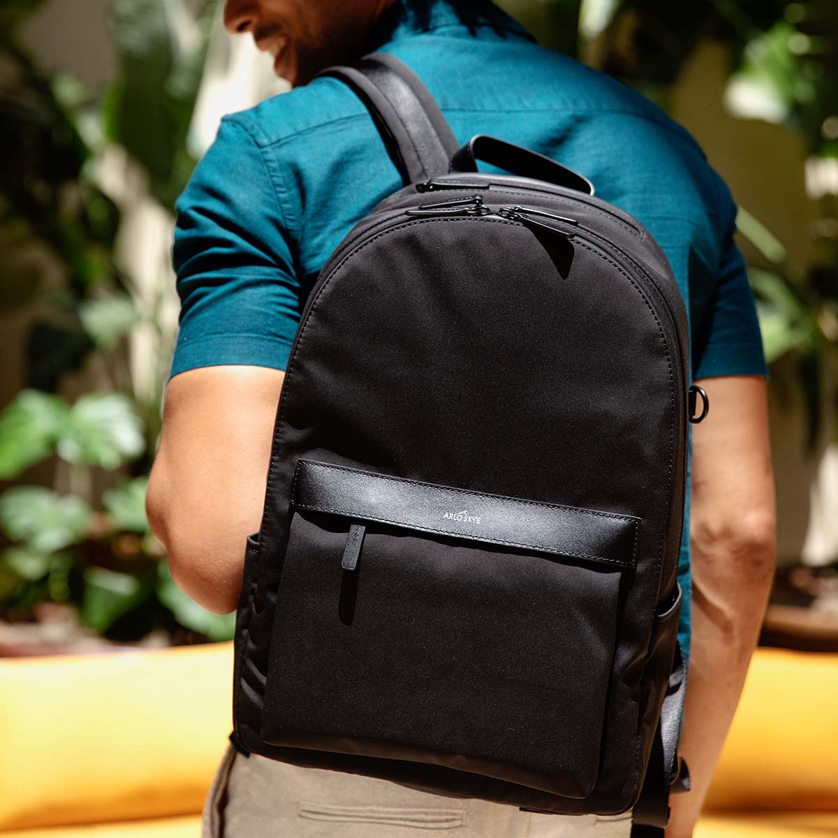 black backpack on shoulder of man