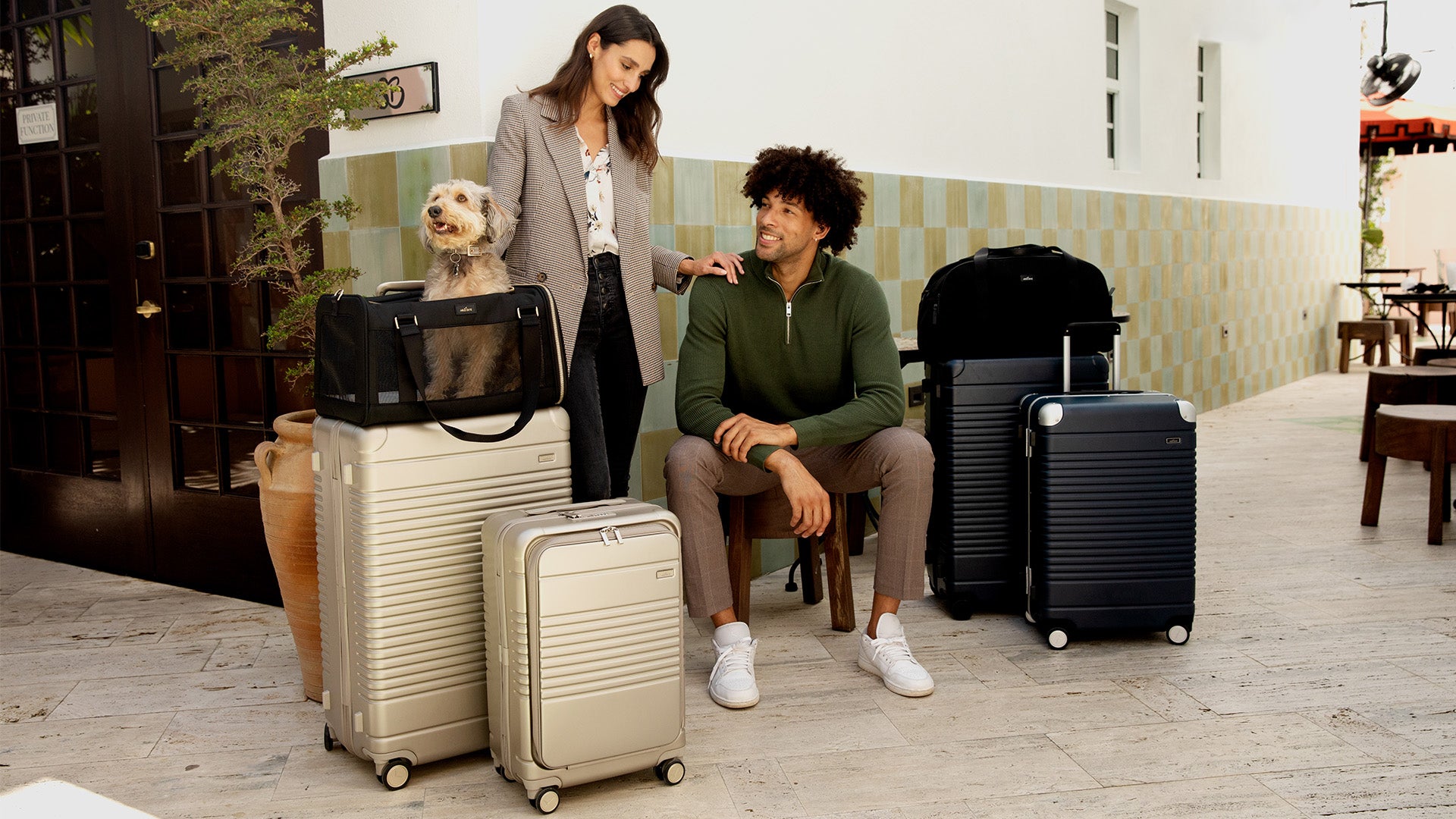 man and woman surrounded by luggage and pet carrier