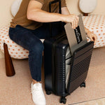 Black expandable carry-on max with the front pocket holding a laptop
