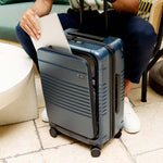 Navy expandable carry-on max with the front pocket holding a laptop