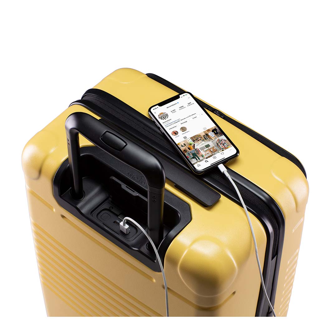 Top down view of the zipper carry-on max with front pocket in yellow with spare charger in use