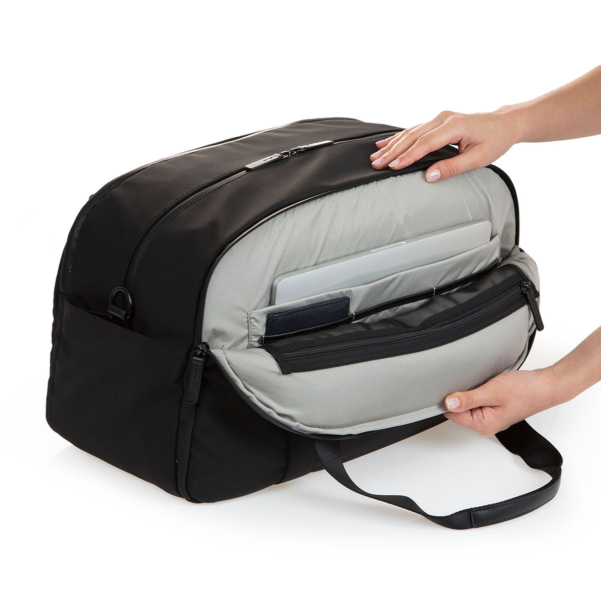 side view of black weekender with side pocket open showing laptop sleeve inside and three slip pockets for passport type items.