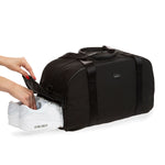 weekender in black - 3/4 angle view showing one pair of shoes being slid into the shoe compartment.